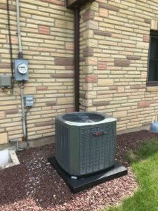 HVAC unit outside a tan brick home