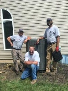 Three Jack Lehr HVAC technicians near an outdoor HVAC unit